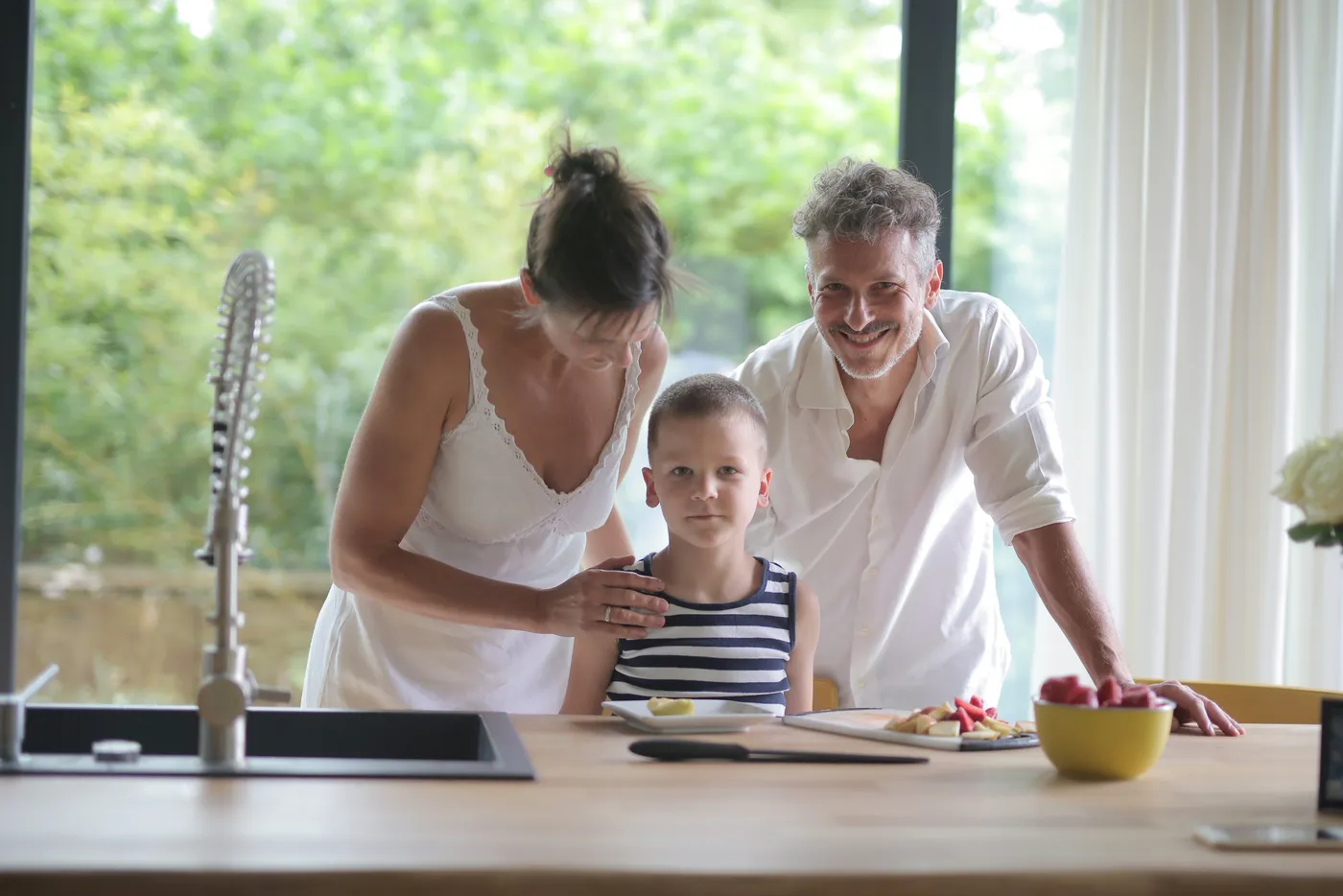 Familie am Küchentisch im Sonnenlicht